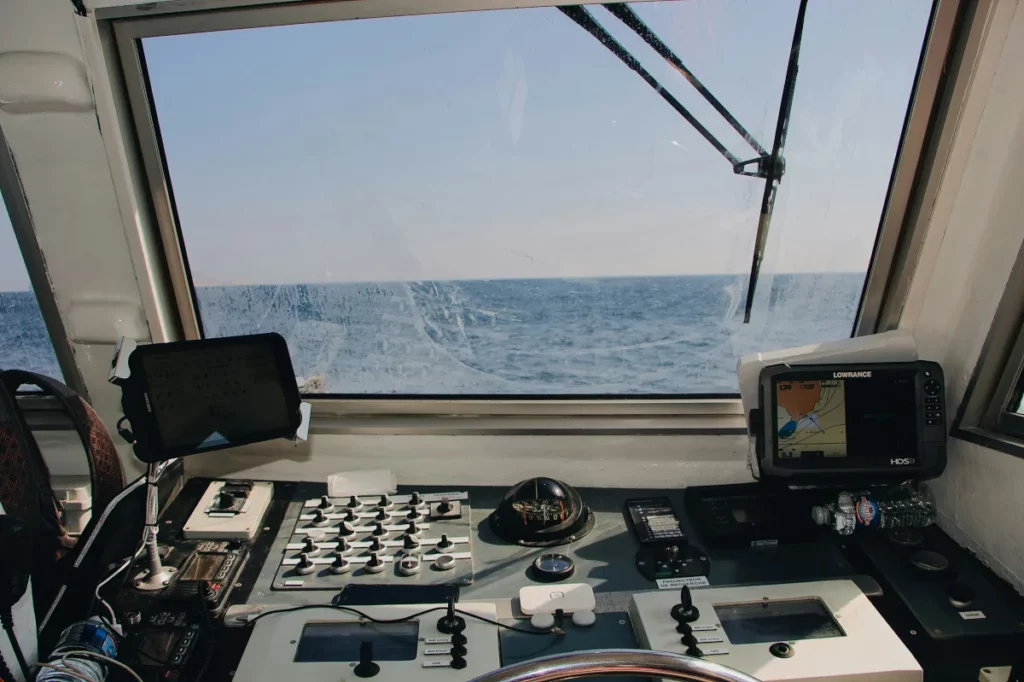 Captain looks out of bridge after entries in cruising logbook